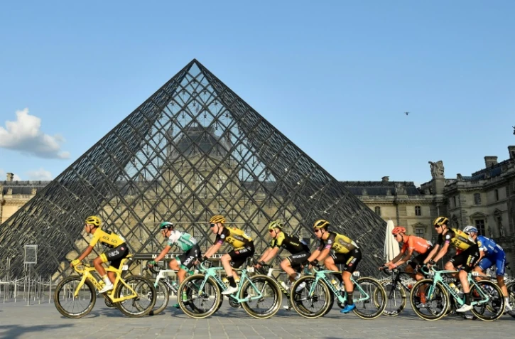 Le Tour de France, qui passe ici au Musée du Louvre lors de son ultime étape, le 28 juillet 2019, fera défaut aux grilles estivales des radios et télés françaises