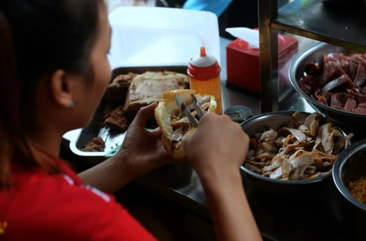Préparaion d'un sandwich appelé banh-mi à Hanoï, le 31 août 2016