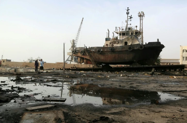 Des ouvriers inspectent les dommages causés par une frappe aérienne sur le centre de maintenance du port de Hodeidah, le 27 mai 2018