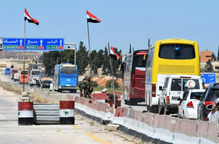 Photo d'un convoi de combattants du groupe rebelle Jaich al-Islam et de leurs familles après leur évacuation de la dernière poche insurgée dans la Ghouta orientale, en Syrie, le 3 avril 2018