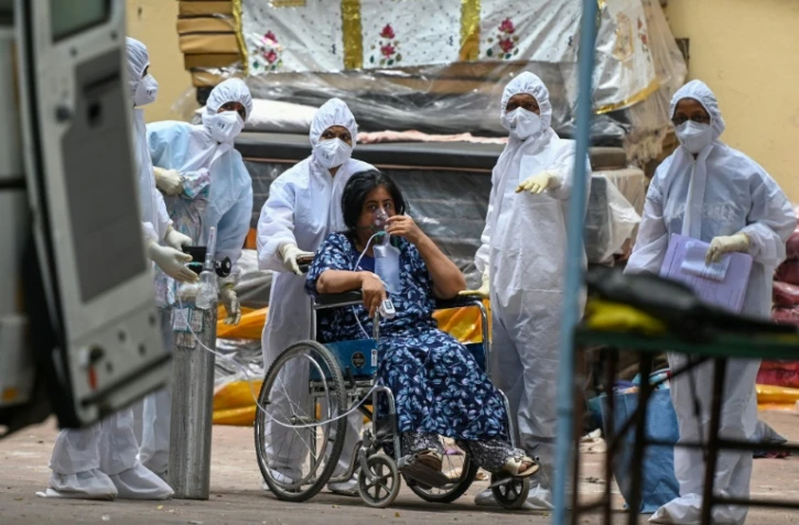 Une femme est emmenée par des ambulanciers pour être transportée dans une unité de soins intensifs pour patients atteints du Covid-19, le 22 avril 2021 à Bombay, en Inde