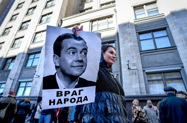Un manifestant brandit une photo du Premier ministre russe Dmitri Medvedev sous laquelle on peut lire "Ennemi du peuple" au cours d'un rassemblement contre la réforme des retraites, à Moscou le 26 septembre 2018.