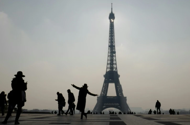 Une femme pose devant la tour Eiffel à Paris, le 21 février 2018