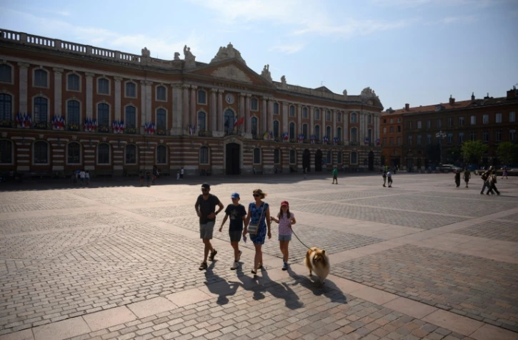 Une famille traverse la place du Capitole Ă Toulouse, le 28 juillet 2024