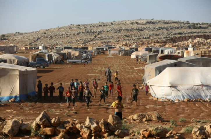 Des enfants se rassemblent dans un camp pour les déplacés à Kafr Dariyan, dans la province syrienne d'Idleb, le 26 août 2018 