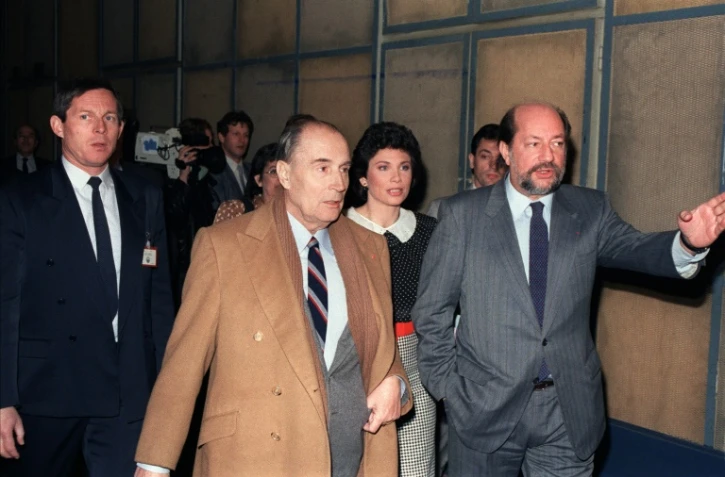 Hervé Bourges (d) président de TF1, François Mitterrand (g) et la journaliste Anne Sinclair (c) avant une émission télévisée le 29 mars 1987 dans les couloirs de TF1 à Paris