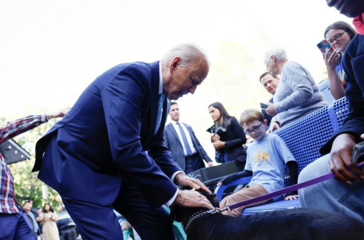 Joe Biden caresse un chien à Baltimore, le 29 octobre 2024