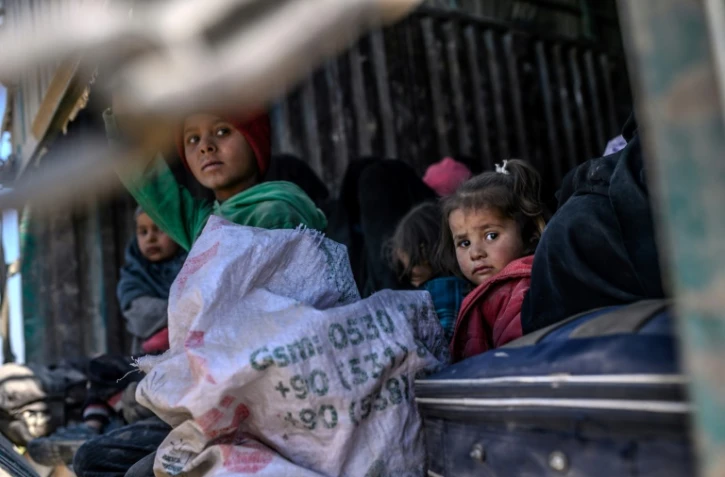 Des enfants et des femmes à bord d'un camion fuient la dernière poche du groupe Etat islamique (EI) à Baghouz, dans l'est de la Syrie, le 20 février 2019