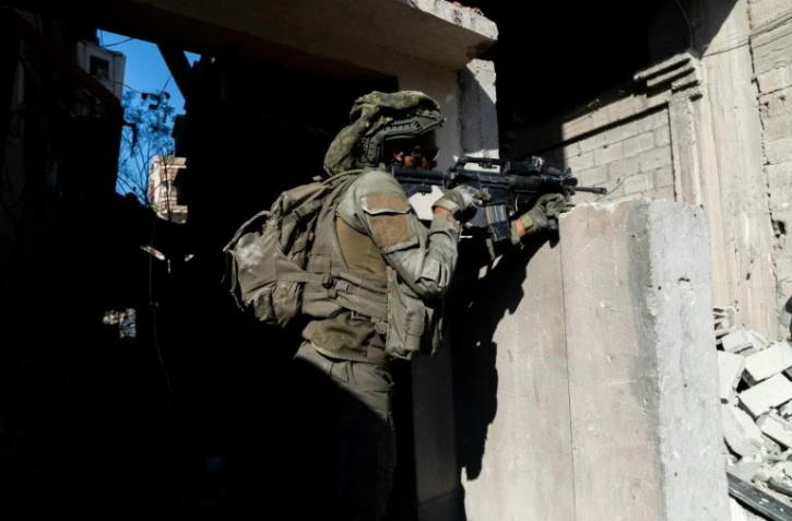 Une photo distribuée par l'armée israélienne le 21 décembre 2023 montre un soldat pendant une opération dans la bande de Gaza