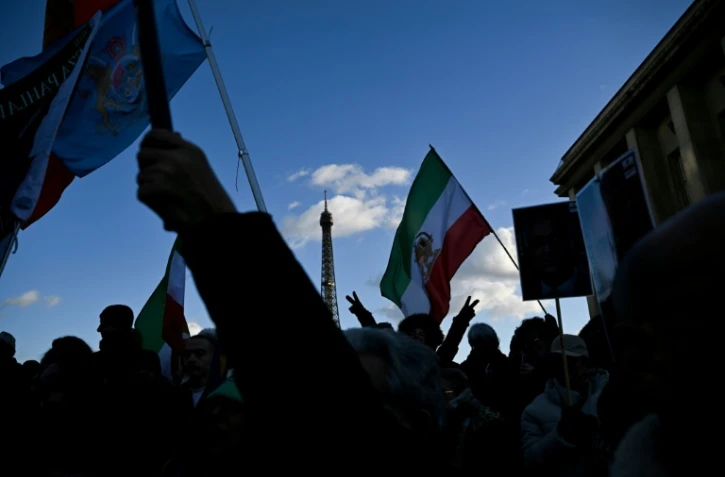 Des manifestants brandissent des drapeaux iraniens d'avant la révolution islamique de 1979 durant un rassemblement à Paris en soutien aux manifestants iraniens, le 4 janvier 2026