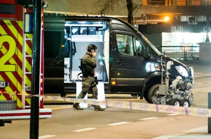 Un policier près d'un robot démineur après la découverte d'un engin suspect ressemblant à une bombe, le 8 avril 2017 à Oslo, en Norvège