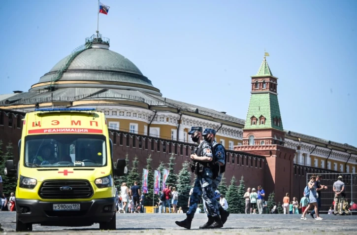 Des soldats de la garde nationale russe en patrouille sur la place Rouge où est stationnée une ambulance, le 18 juin 2021 à Moscou
