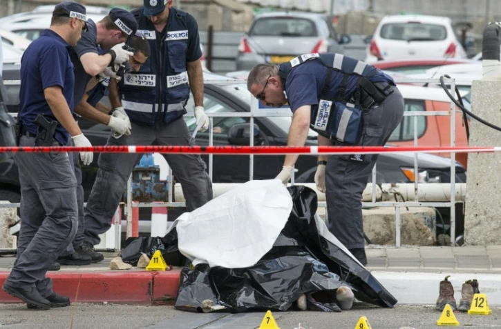 Les forces de sécurité israéliennes inspectent le corps d'un Palestinien abattu après avoir agressé au couteau une soldate israélienne et trois passants dans la ville côtière de Tel Aviv, en Israël, le 8 octobre 2015