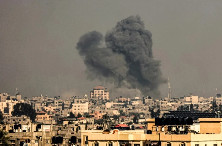 Photo prise depuis Rafah montrant un panache de fumée après un bombardement sur Khan Younès, dans le sud de la bande de Gaza, le 8 décembre 2023