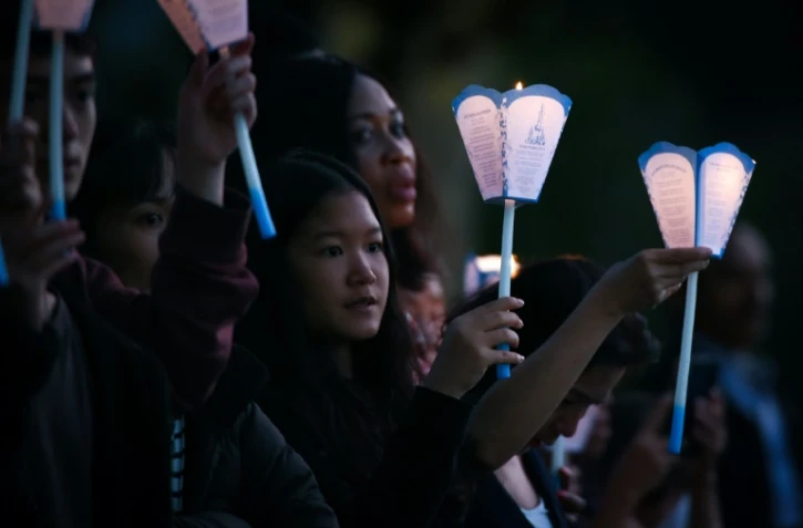 Des pèlerins, flambeau en main, lors de la procession aux flambeaux à Lourdes, le 14 août 2022