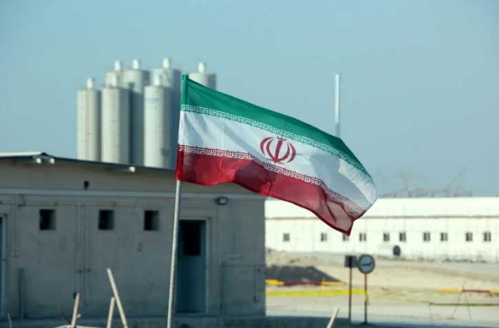 Une photo prise le 10 novembre 2019 montre un drapeau iranien devant la centrale nucléaire de Bouchehr