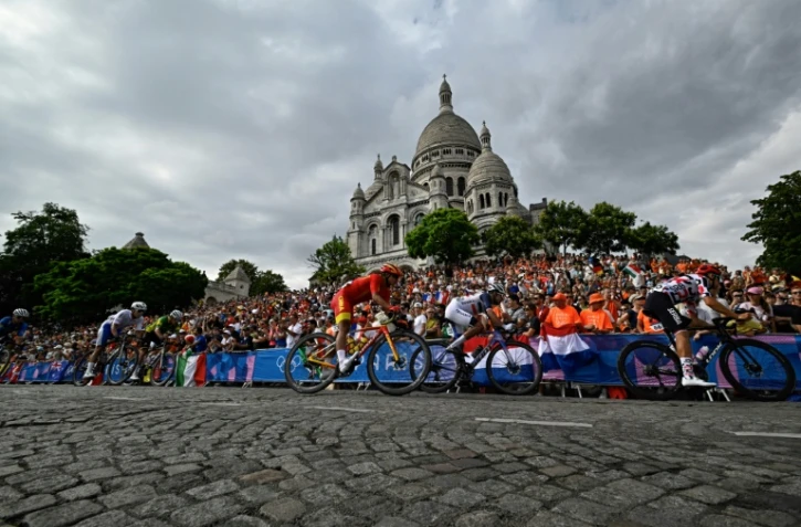 Le peloton passe devant la basilique du Sacré-Coeur à Montmartre lors de la course en ligne hommes des Jeux olympiques de Paris, le 3 août 2024
