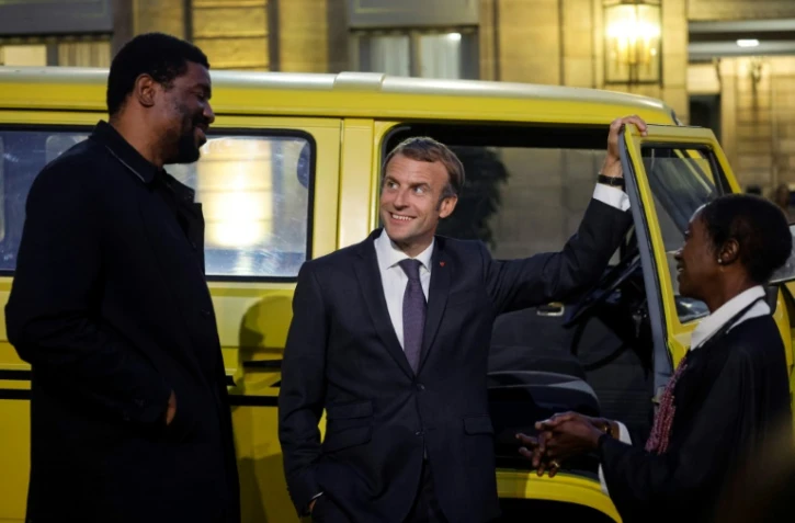 Le président Emmanuel Macron en discussion avec l'artiste nigérian Emeka Ogboh et la présidente de la programmation Africa2020 N&rsquo;Goné Fall, à Paris le 30 septembre 2021