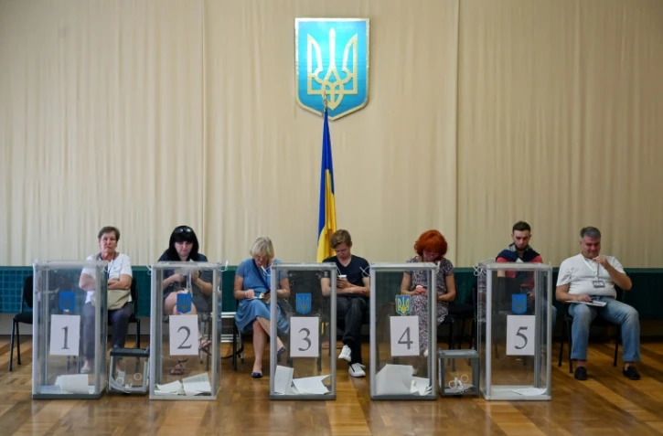 Des observateurs installés près des urnes dans un bureau de vote, lors des législatives, le 21 juillet 2019 à Kiev, en Urkaine