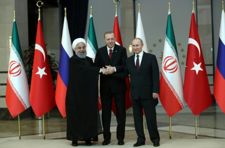 Les présidents turc Recep Tayyip Erdogan, russe Vladimir Poutine et iranien Hassan Rohani ont échangé une poignée de main devant les caméras avant d'entamer les discussions au palais présidentiel à Ankara le 4 avril 2018.