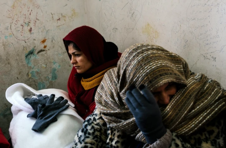 Une femme (g), avec son bébé dans les bras, attend le 19 janvier 2016 dans la gare de Presevo, en Serbie, un train pour gagner la Croatie
