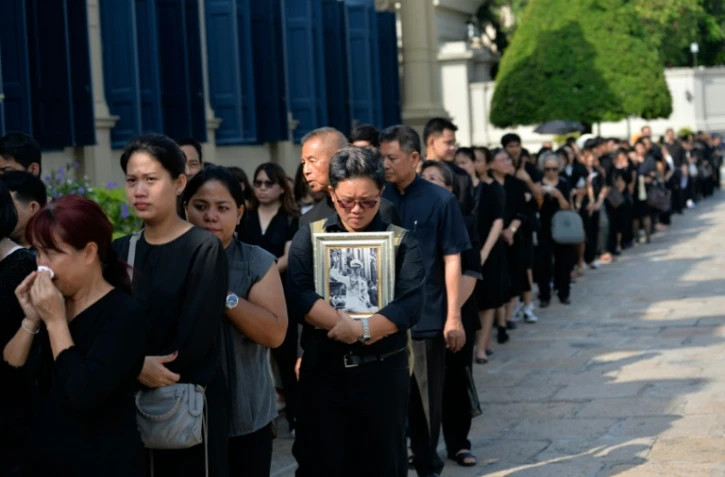 Des Thaïlandais habillés en noir font la queue pour rendre un dernier hommage à leur défunt roi Bhumibol Adulyadej, au Grand Palais de Bangkok, le 14 octobre 2016.