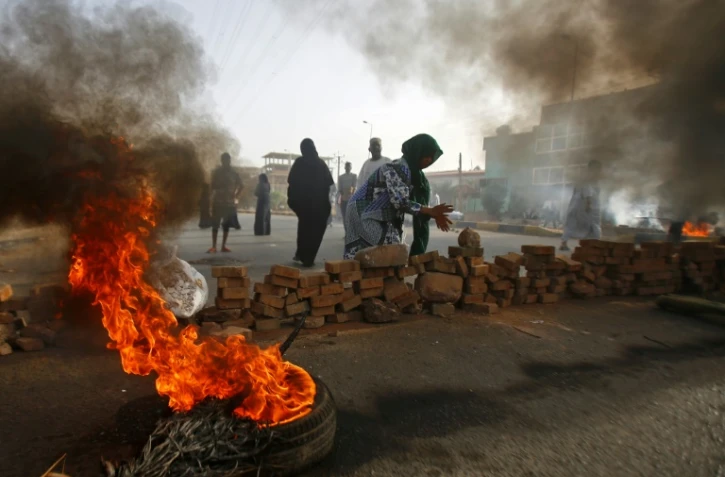 Des manifestants soudanais font brûler des pneus et érigent des barricades, le 3 juin 2019 à Khartoum