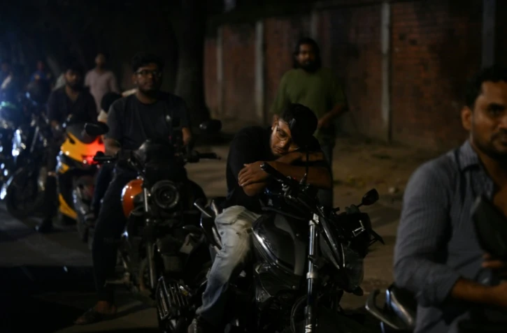 Un homme fait la sieste sur sa moto dans une file d'attente pour du carburant à Dacca, capitale du Bangladesh, le 21 avril 2026