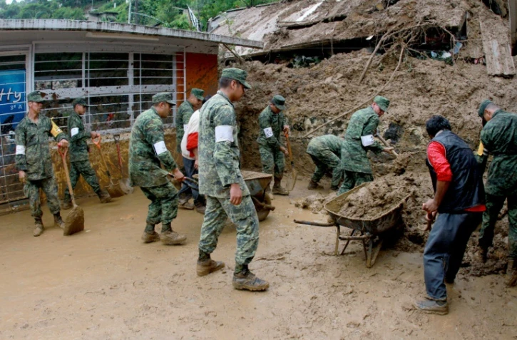 Des soldats mexicains aident à déblayer des maisons endommagées par les glissements de terrains provoquées par les pluies de la tempête Earl, dans la région de Xalapa dans l'Etat de Veracruz au Mexique, le 06 août 2016