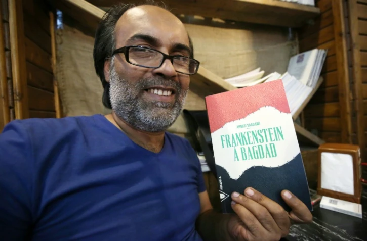 L'écrivain irakien Ahmed Saadawi pose avec son roman "Frankenstein a Bagdad" le 4 août 2016 à Bagdad