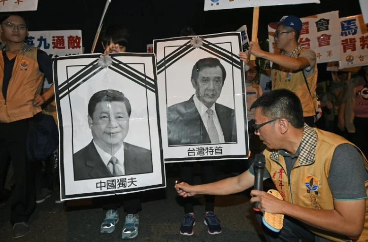 Un militant pour l'indépendance de Taïwan s'apprête à brûler des photos des dirigeants chinois et taïwanais, le 7 novembre 2015 à Taipei