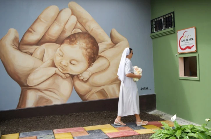 La bénédictine polonaise Agnieszka Olejnik, du foyer Valle Feliz, montre la Cuna de Vida (Berceau de vie), ouverture discrète où les mères peuvent laisser leur bébé sans donner d'explications, le 17 janvier 2020 à Santo Domingo de los Colorados (Equateur)