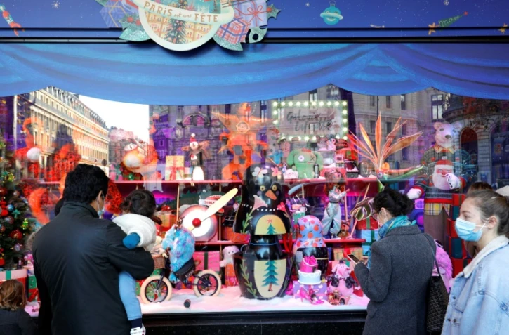 Des personnes admirent les vitrines de Noël des Galeries Lafayette, le jour de la réouverture des commerces non essentiels, le 28 novembre 2020 à Paris