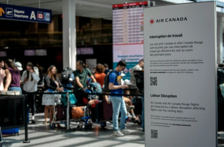 Des passagers en attente à l'aéroport de Montréal (Canada) le 16 août 2025 à la suite d'un mouvement de grève des hôtesses et stewards d'Air Canada
