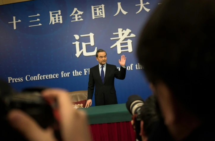 Le ministre chinois des Affaires étrangères, Wang Yi, salue les photographes à son arrivée pour une conférence de presse le 8 mars 2018, à Pékin.