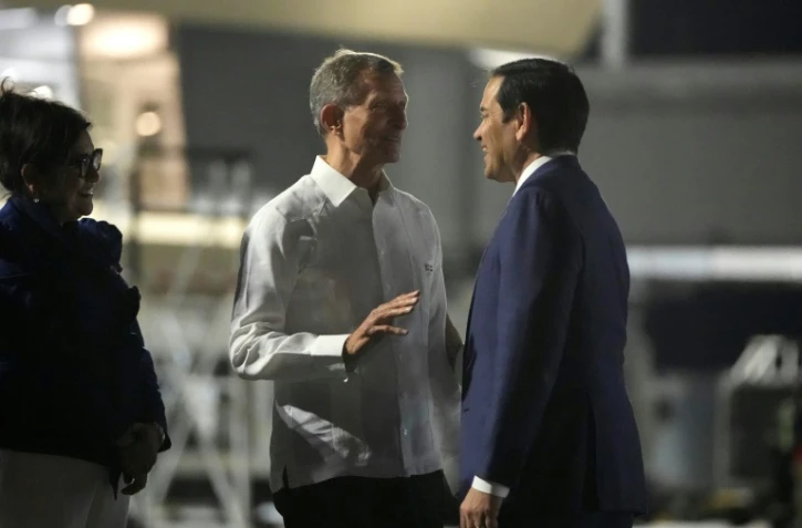Le secrétaire d'Etat américain Marco Rubio (d.) reçu par le ministre des Affaires étrangères de la République dominicaine, Roberto Alvarez, sur le tarmac de l'aéroport international de Saint-Domingue, le 5 février 2025