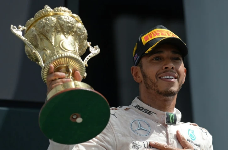 Le Britannique Lewis Hamilton (Mercedes), soulève le trophée après sa victoire au GP de Grande-Bretagne sur le circuit de Silverstone, le 10 juillet 2016