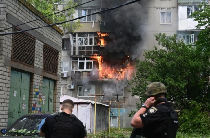 Des policiers face à un bâtiment en flammes après une frappe aérienne dans le centre de Kramatorsk, en Ukraine, le 19 juillet 2022