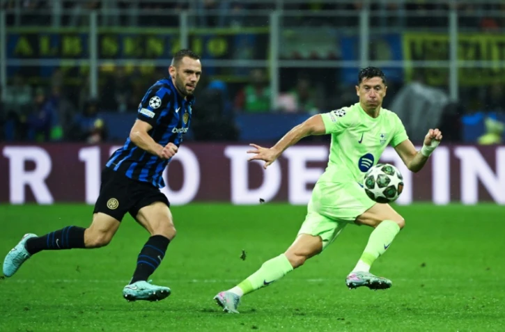 Le défenseur de l'Inter Milan Stefan de Vrij et l'attaquant barcelonais Robert Lewandowski (d) à la lutte lors de la demi-finale retour de Ligue des champions, le 6 mai 2025 à Milan