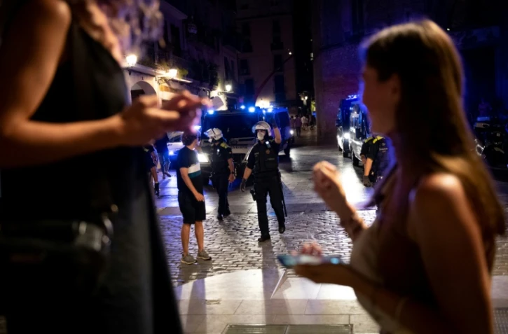 La police demande aux personnes qui participent à une soirée de quitter les lieux alors que le couvre-feu entre en vigueur dans le quartier de Born, à Barcelone, le 17 juillet 2021.
