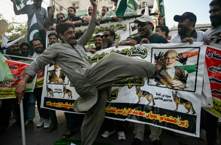 Un manifestant donne un coup de pied à une image du Premier ministre indien Narendra Modi, le 29 avril 2025 à Karachi, au Pakistan