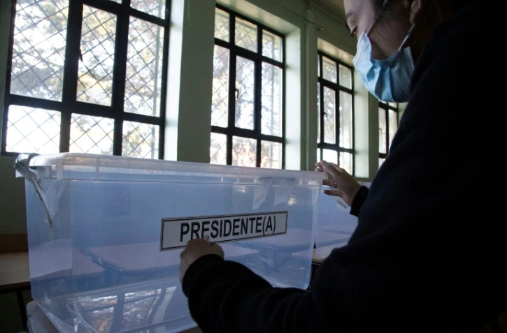 Une femme place une étiquette sur une urne électorale avant l'élection présidentielle au Chili,  à l'école Portugal de Punta Arenas, Chili, le 20 novembre 2021
