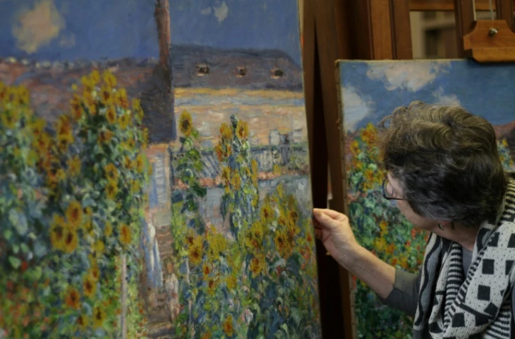 Ann Hoenigswald, restauratrice à la National Gallery of Art, compare deux versions du tableau "Le jardin de l'artiste à Vétheuil", le 17 mai 2018 à Washington