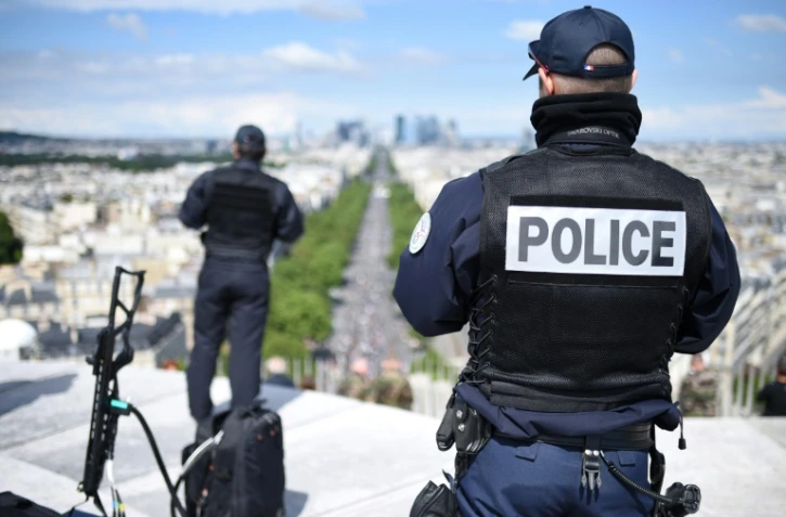 Des policiers suveillent le défilé militaire depuis le sommet de l'Arc de Triomphe, le 14 juillet 2016 à Paris