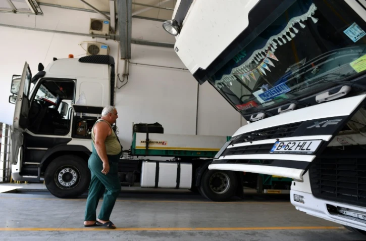 un chauffeur routier marche vers son camion dans un garage à Bucarest le 18 août 2017