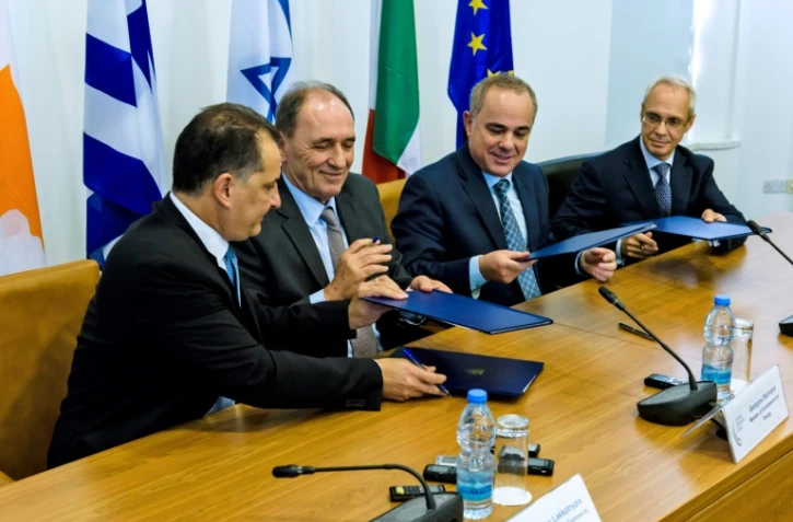 (G à D): le ministre chypriote de l'Energie Georgios Lakkotrypis, grecque Giorgos Stathakis, israélien Yuval Steinitz et  l'ambassadeur d'Italie à Chypre Andrea Cavallari, échangent des documents lors d'un accord sur le gazoduc Eastmed à Nicosie le 5 décembre 2017