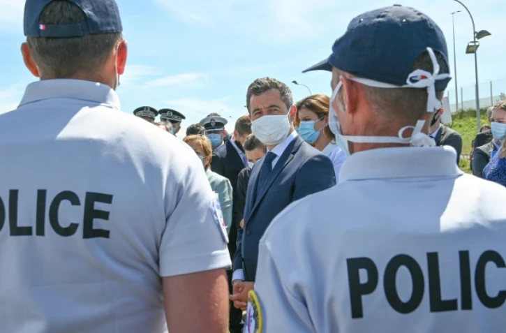 Le ministre de l'Intérieur français Gérald Darmanin (c) discute avec des policiers à Calais (Pas-de-Calais), le 12 juillet 2020