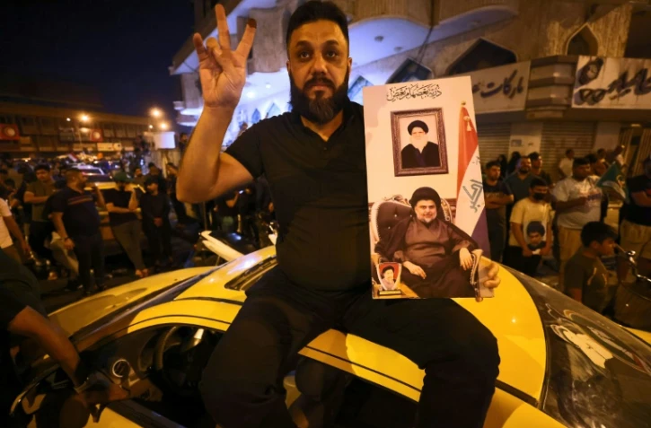 Des supporters du chef religieux chiite Moqtada al-Sadr célèbrent la victoire de son courant le 11 octobre 2021 à Bagdad après l'annonce des résultats préliminaires le donnant gagnant
