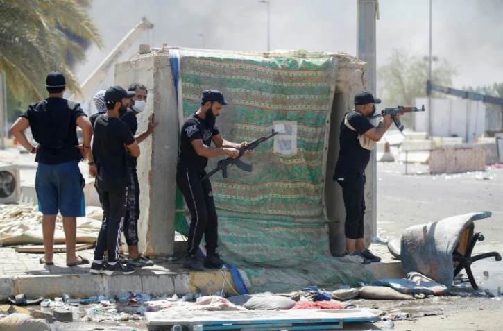 Des partisans armés de Moqtada Sadr lors des combats dans la Zone verte à Bagdad, le 30 août 2022