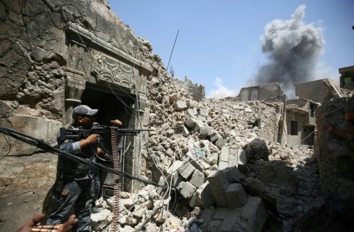 Des soldats des forces armées irakiennes tirent sur une position des jihadistes de l'EI, dans la Vieille ville de Mossoul, le 28 juin 2017
